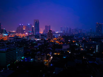 Illuminated buildings in city against sky at night