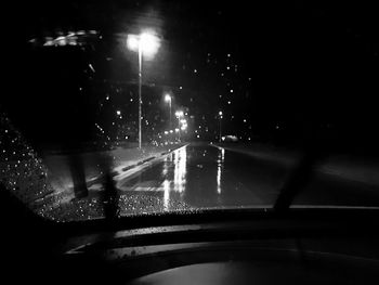 Close-up of wet car on road at night