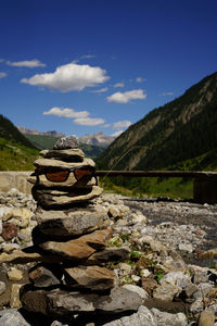 Stack of stones on rock against sky