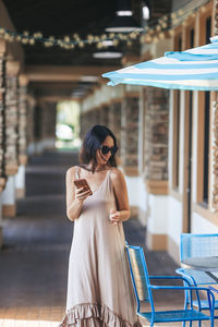 Portrait of young woman standing in city