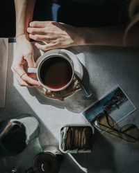 Cropped image of woman having coffee at table