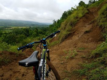 Bicycle on road by mountain against sky