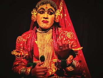 Close-up of man wearing mask against black background