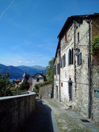 Road amidst houses against sky