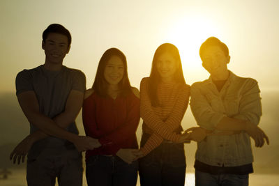 People standing against sky during sunset