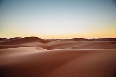 Scenic view of desert against cloudy sky