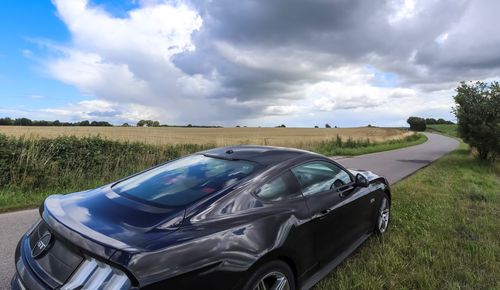 Car parked on field against sky