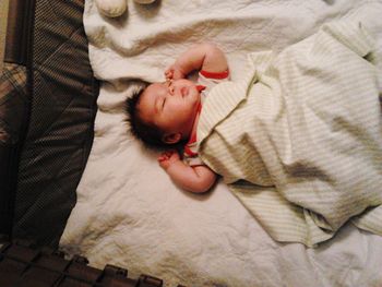 High angle view of baby sleeping on bed