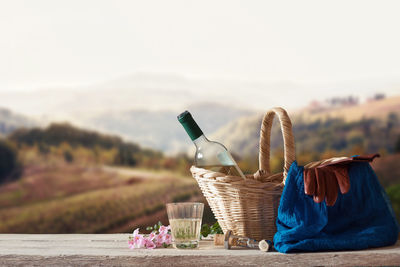 Close-up of wine bottles on table against sky