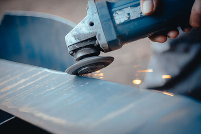 Close-up of hand holding machine part