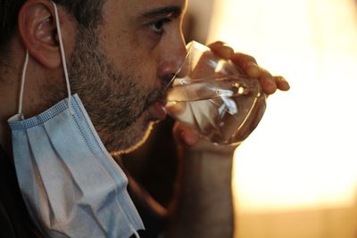 Close-up portrait of young man drinking glass