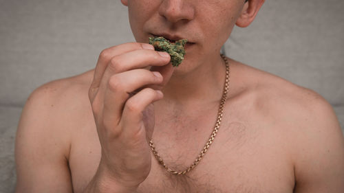 Midsection of man smelling marijuana