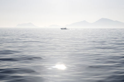 Scenic view of sea and mountains against sky