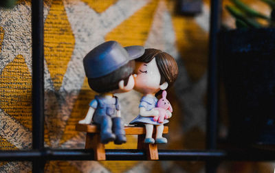 Kissing toy sitting on wooden bench