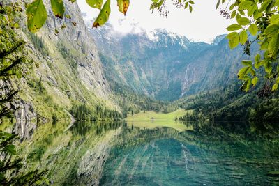 Scenic view of lake by mountains against sky