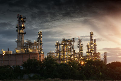 Illuminated factory against sky at night