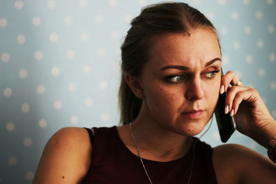 Close-up of woman listening to smart phone