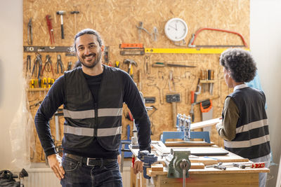 Portrait of confident male technician standing with hand on hip at recycling center