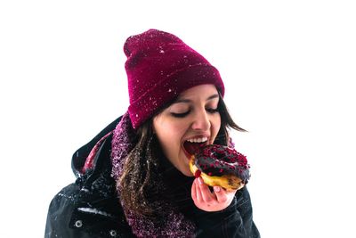 Young woman eating ice cream against white background