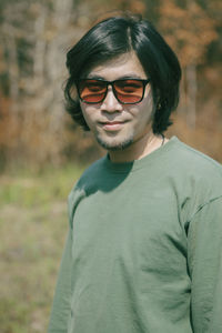 Portrait of young man wearing sunglasses standing outdoors