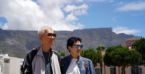 Smiling senior couple standing against mountain