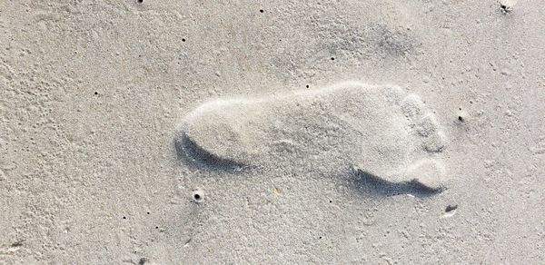 High angle view of footprints on sand