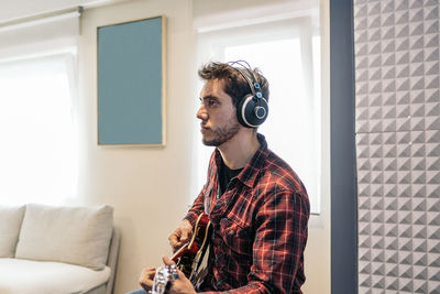 Man looking away while sitting on sofa