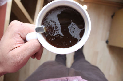 Low section of man holding coffee cup