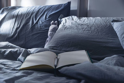 Midsection of person relaxing on bed at home