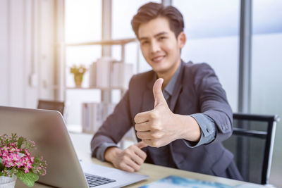 Young man using mobile phone while sitting on table