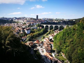 Aerial view of bridge in city against sky