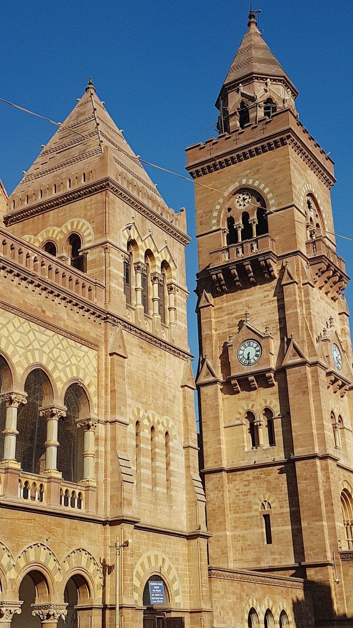 religion, architecture, place of worship, building exterior, spirituality, low angle view, built structure, history, outdoors, no people, clear sky, blue, day, sunlight, clock tower, bell tower, sky