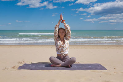 Beautiful young blonde doing pilate, yoga on the beach