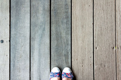 Low section of woman standing on wooden floor