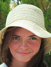 Close-up portrait of beautiful young woman wearing hat