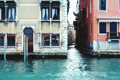 Canal by old building in city