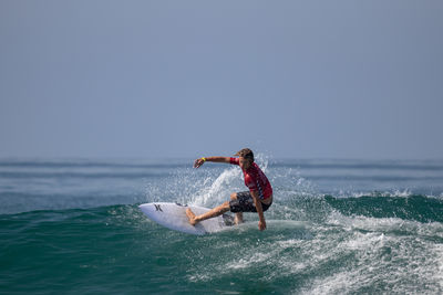 Man surfing on sea against sky