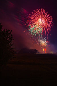 Low angle view of firework display at night