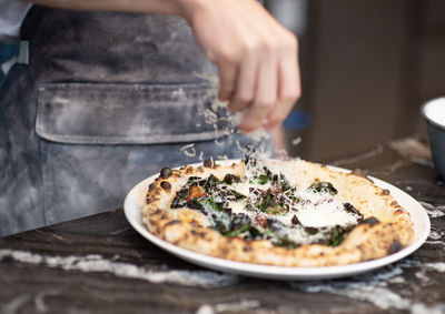 Midsection of person holding pizza