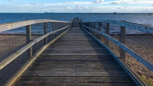 Boardwalk amidst sea against sky