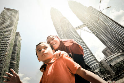Low angle view of woman against modern buildings