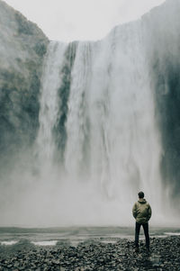 Rear view of man standing in sea