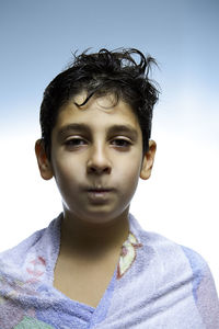 Portrait of boy wrapped in towel against clear sky