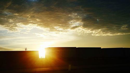 Silhouette of building against sunset sky