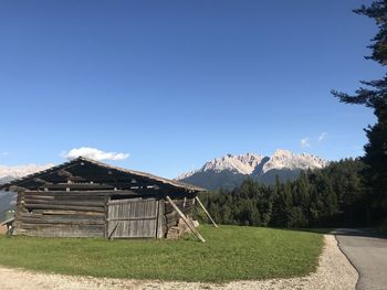 Built structure on field against clear blue sky