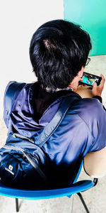 Rear view of boy sitting at home