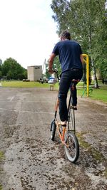 Rear view of man riding bicycle