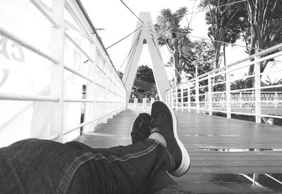 Low section of person relaxing on bridge