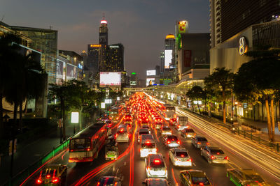 Traffic on city street amidst buildings at night