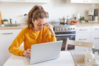 Young woman using laptop at home